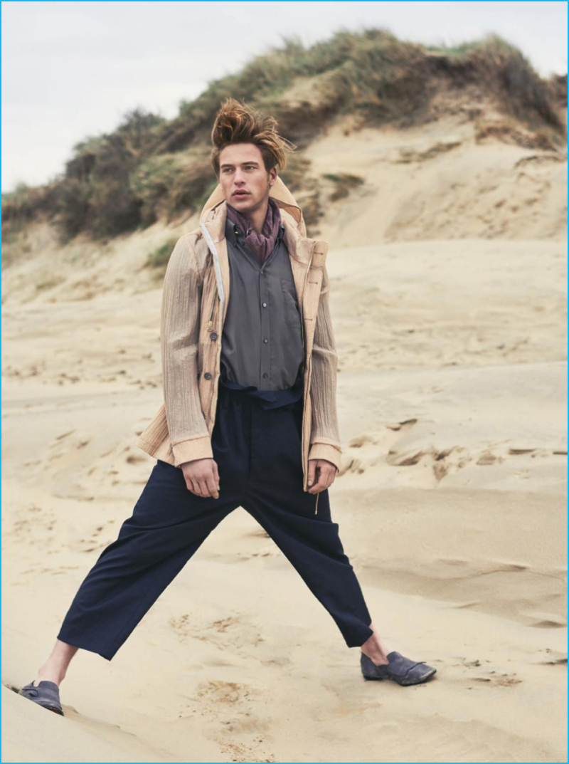 Playing the avid adventurer, Jules Raynal models a Corneliani parka withcropped Versace trousers.