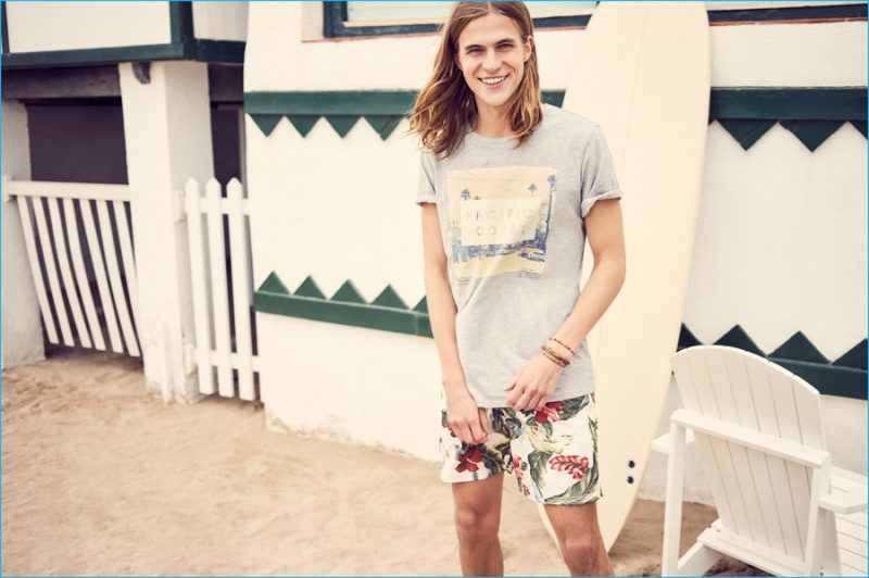 Malcolm Lindberg rocks a graphic t-shirt with floral print shorts from Mango.