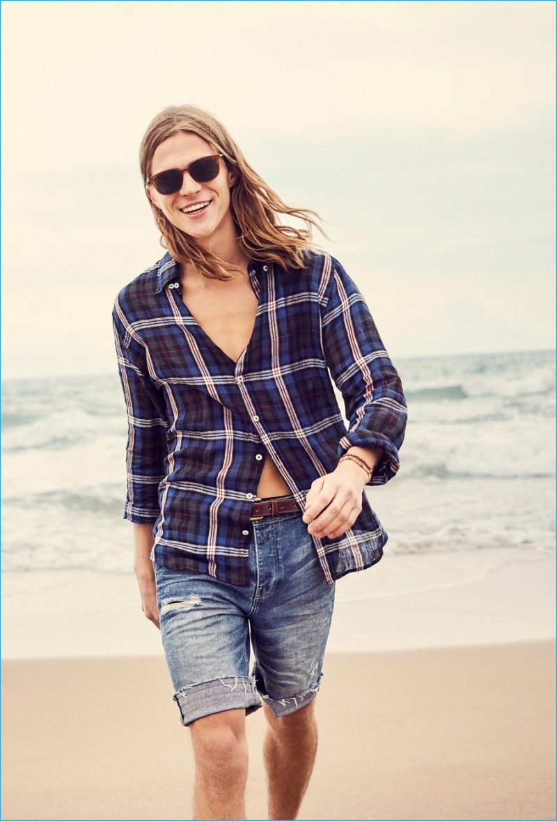 Malcolm Lindberg is an easy vision in a plaid button-down shirt and denim shorts from Mango Man.