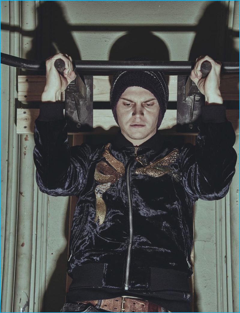 Evan Peters does pull-ups in a Dries Van Noten jacket.