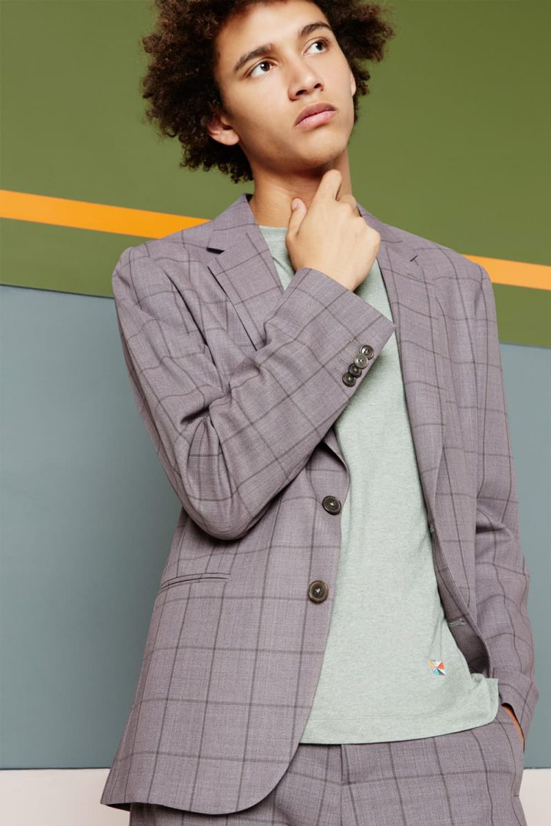 Jackson Hale charms in a windowpane print suit from Paul Smith that has been paired with a sweater.