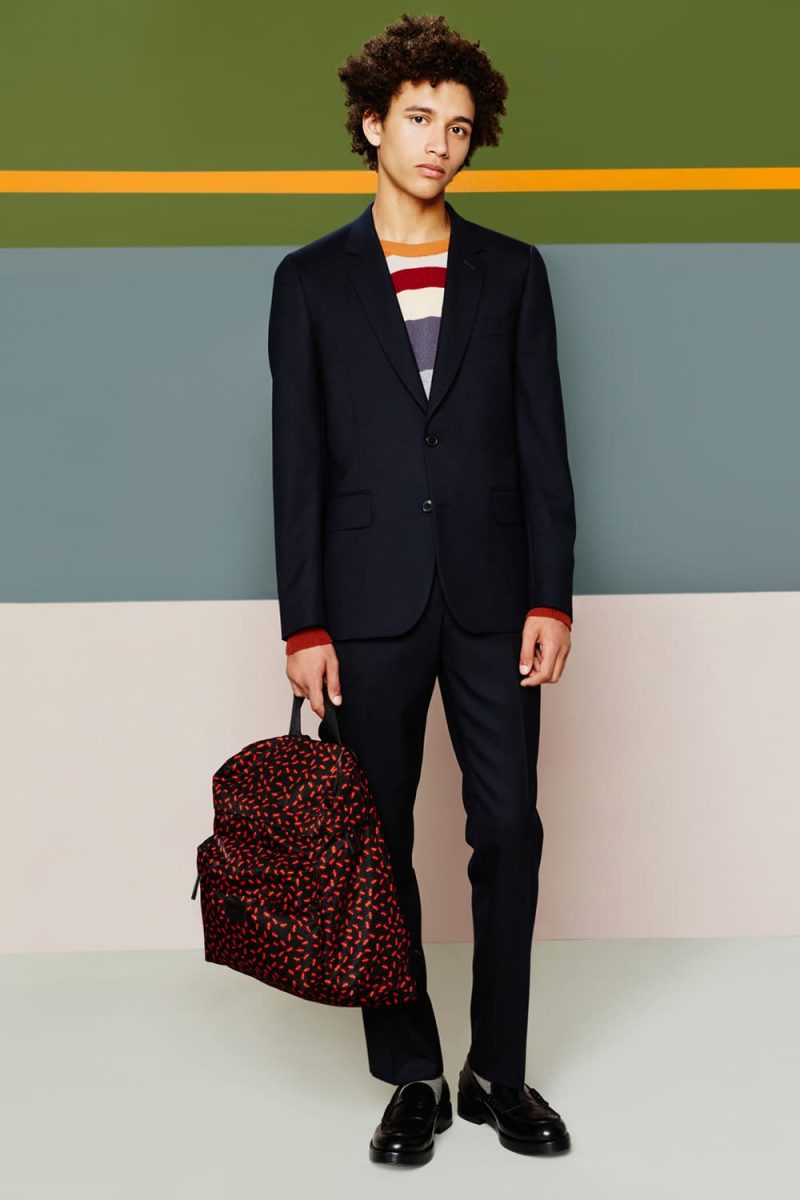 Jackson Hale cleans up in a sleek navy Paul Smith suit, complemented by a striped sweater.