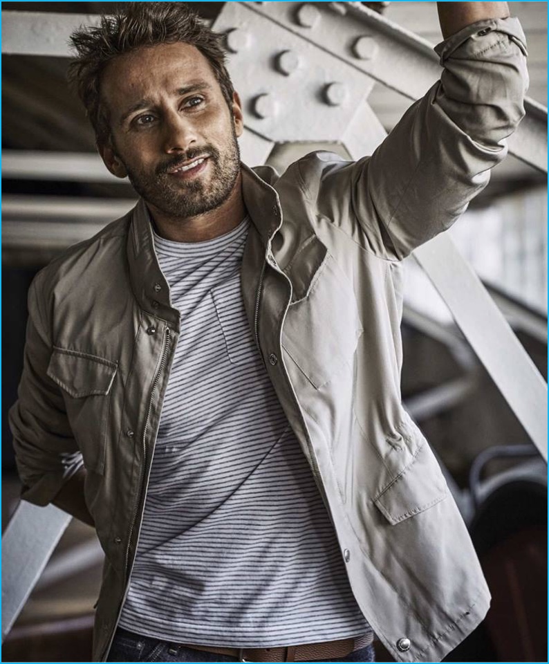 Matthias Schoenaerts is all smiles in a military style jacket and striped pocket tee.