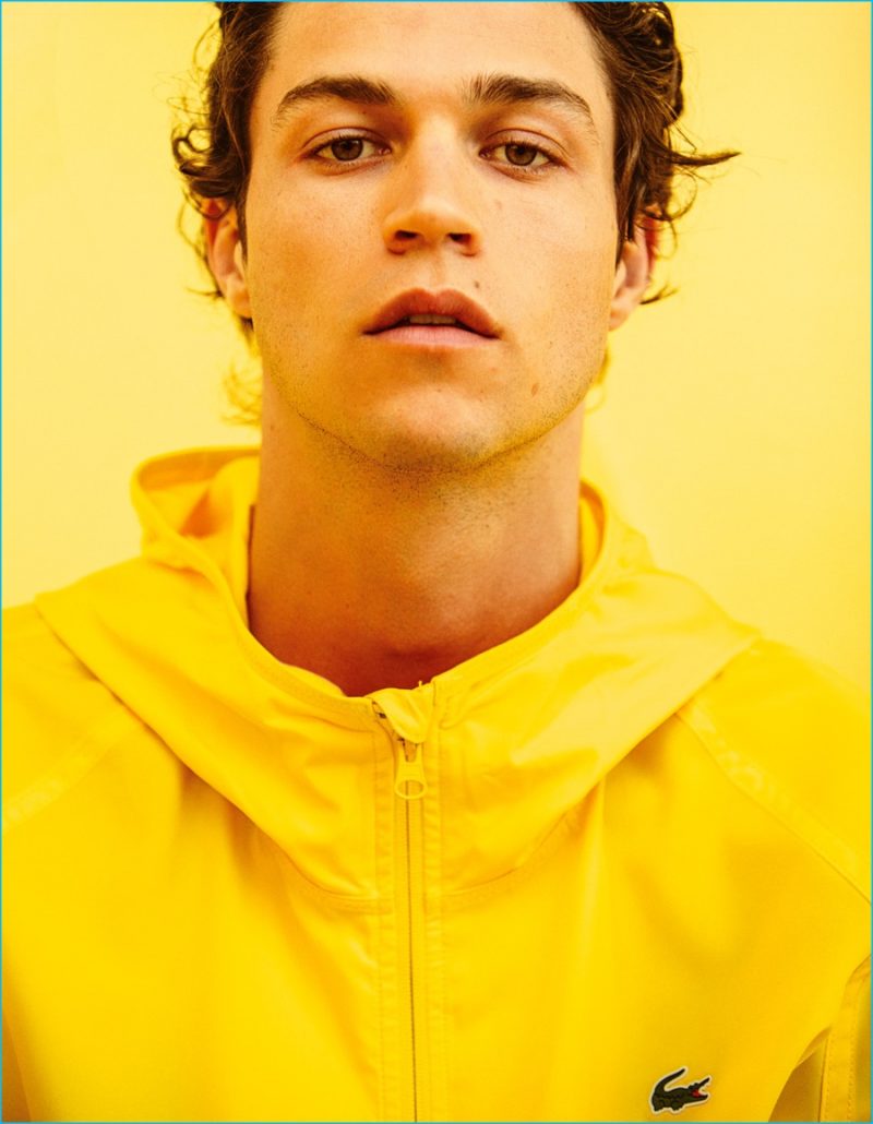 Miles McMillan embraces a bright pop of yellow in a Lacoste jacket.
