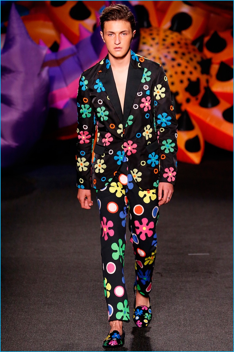 Anwar Hadid makes his runway debut, wearing a groovy flower print suit from Moschino.