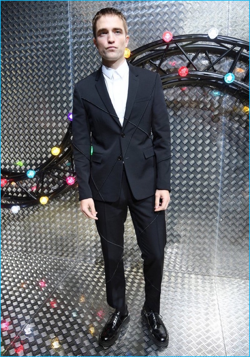 June 2016: Robert Pattinson poses for pictures at Dior Homme's spring-summer 2017 show during Paris Fashion Week. Pattinson dons a sharp, modern suit from the French fashion house.