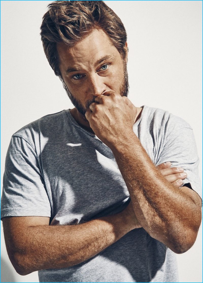Travis Fimmel goes casual in a plain grey crewneck for his Esquire photo shoot.