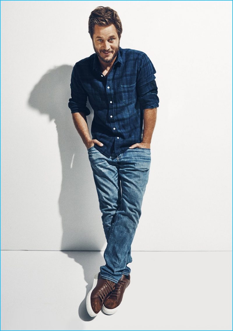 Travis Fimmel sports a plaid Simon Miller shirt with distressed Rag & Bone denim jeans.