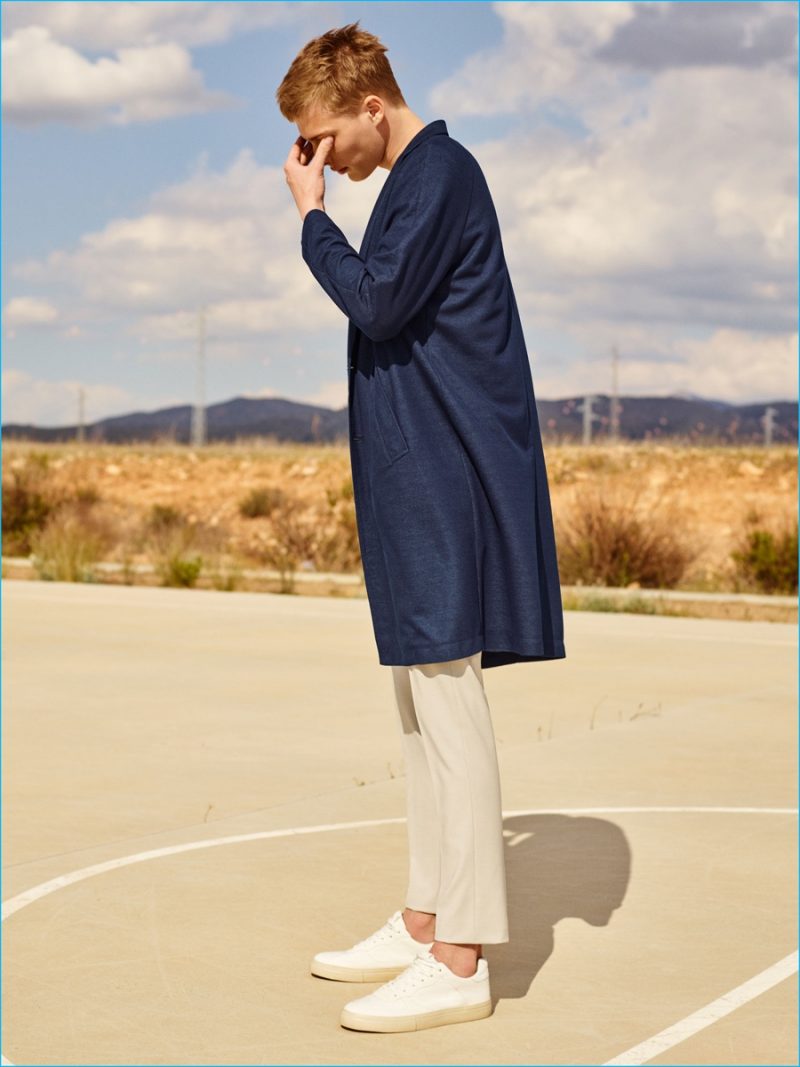 Summer Covering: Otto-Valter Vainaste wears a sleek indigo coat with cropped chino trousers and retro sneakers from Zara Man.
