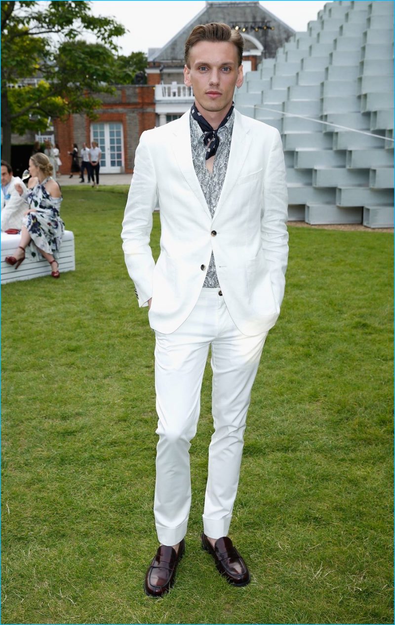 July 2016: Jamie Campbell Bower attends the 2016 Serpentine Summer Party in a white tailored look from Tommy Hilfiger.