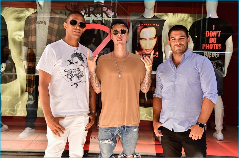 Pictured alongside Barneys New York men's EVP, Jay Bell and Bravado CEO, Mat Vlasic, Justin Bieber poses in front of Barneys New York's storefront, showcasing his collection.