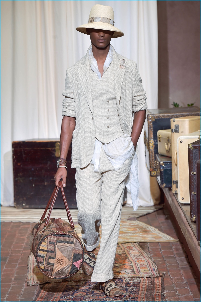 Brad Allen carries one of Joseph Abboud's printed bags for the season as he takes to the catwalk in a three-piece suit from the brand's spring-summer 2017 collection.