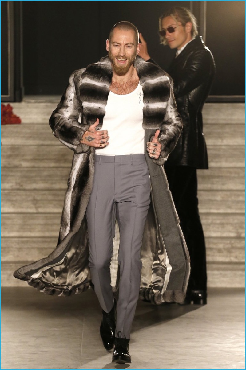 Justin O'Shea hits the catwalk in a chinchilla coat for the finale of his debut Brioni runway show.