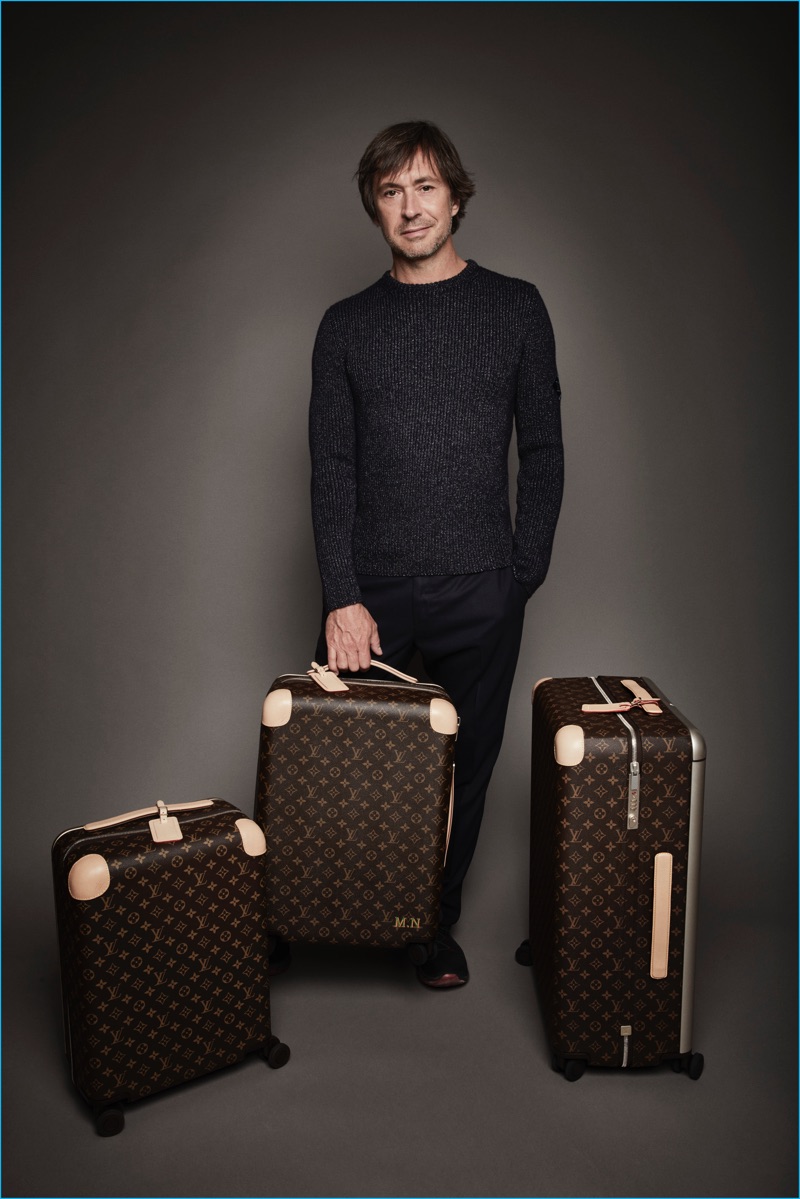 Designer Marc Newson poses with Monogram rolling trunks from his collaboration with Louis Vuitton.