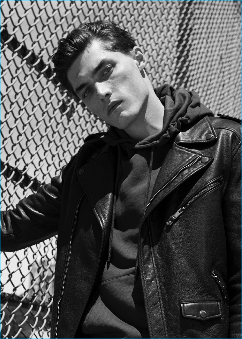 Isaac Weber pictured in a hooded pullover and leather biker jacket from Mango.