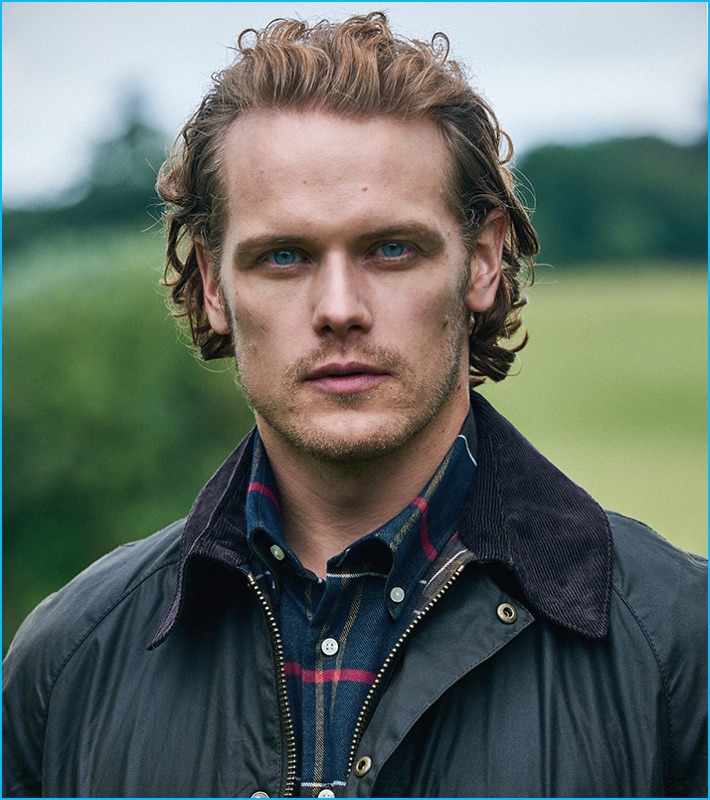 Sam Heughan poses in a classic Barbour jacket and tartan shirt as the label's first global brand ambassador. 