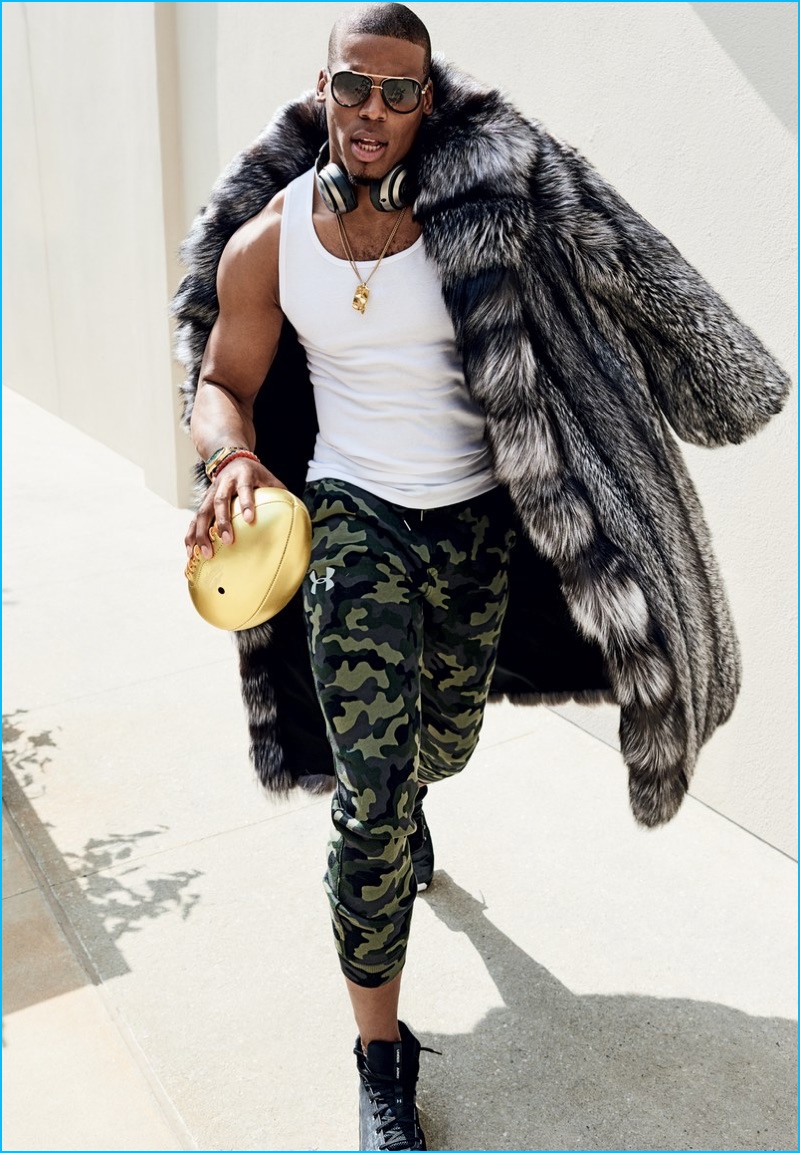 Rocking Dita sunglasses, Cam Newton sports a Marc Kaufman fur coat with Under Amour sneakers and camouflage joggers.