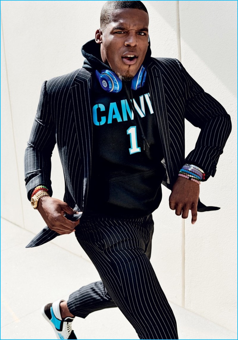 Cam Newton wears a pinstripe Ralph Lauren suit with a King Threads hoodie.