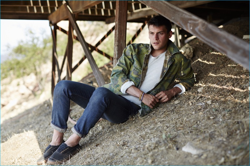 Miles Garber relaxes in denim jeans, a classic fit tee, and a reversible jacket from Current/Elliott's fall-winter 2016 men's collection.