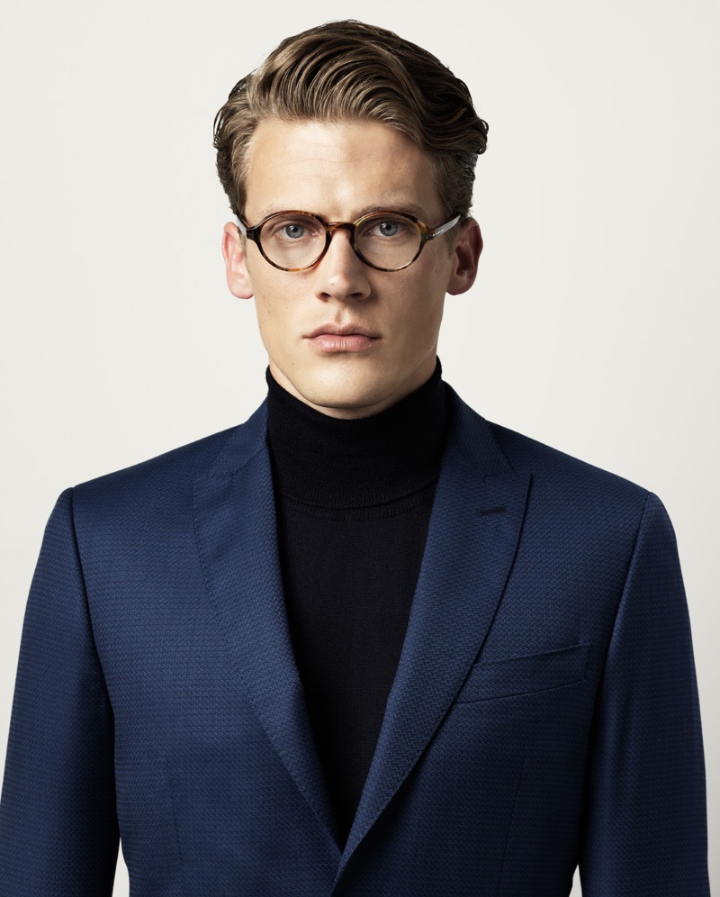 Jimmy wears blazer Marciano by Guess, turtleneck sweater Scapa, and glasses Tom Ford.