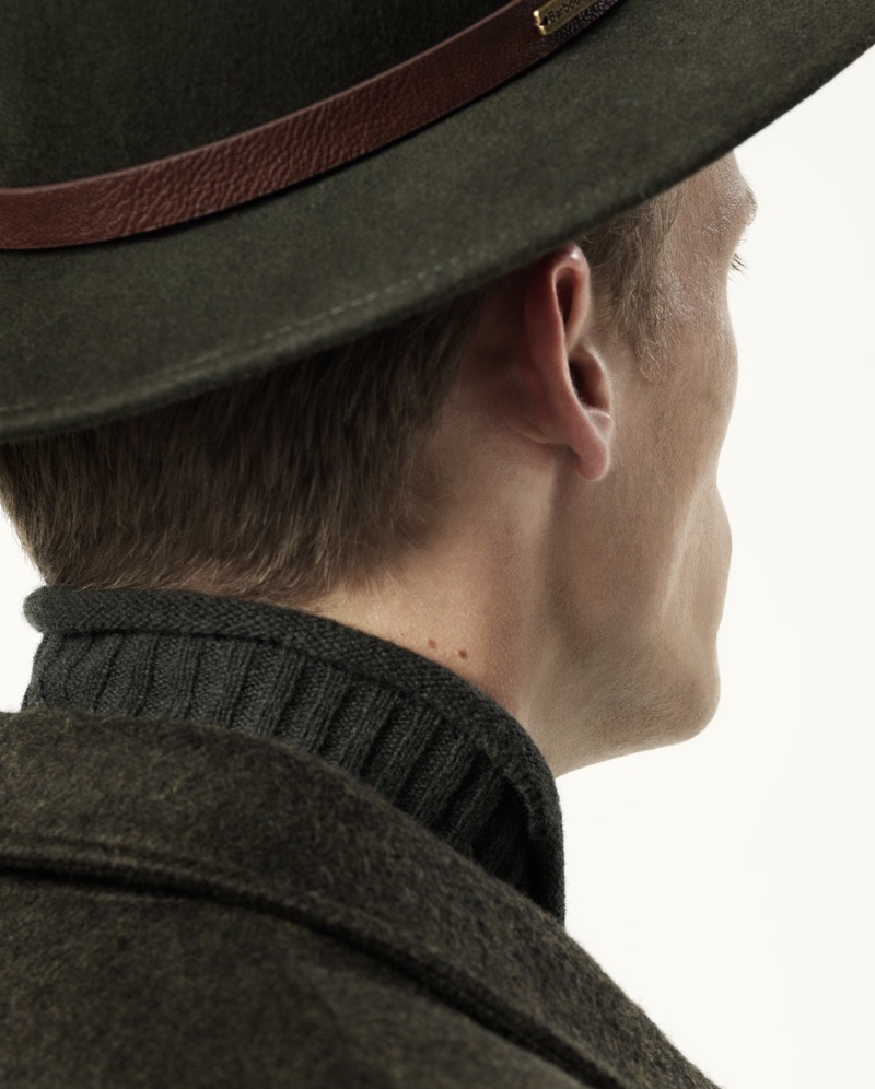 Jimmy wears turtleneck sweater Samsøe & Samsøe, coat Scapa, and hat Barbour.