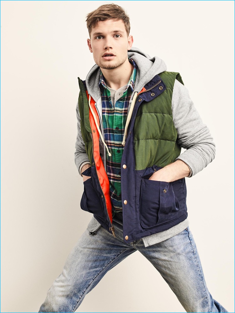 Ready to head outdoors, Stefan Pollmann is pictured in Gap's ColdControl Max heavyweight puffer vest with a plaid button-down, henley, full-zip sweatshirt, and distressed denim jeans.