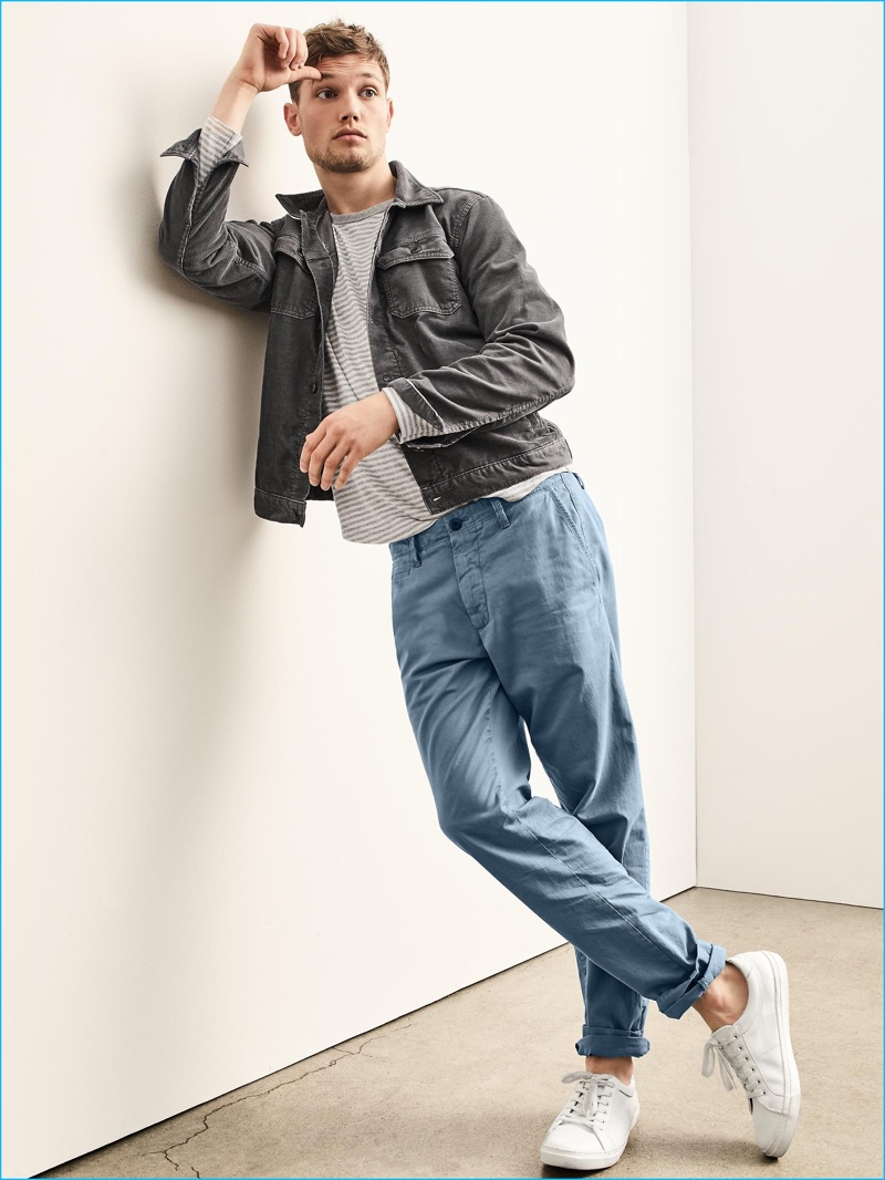Embracing workwear-inspired style, Stefan Pollmann is pictured in a grey corduroy jacket, striped tee and chinos with white sneakers from Gap.