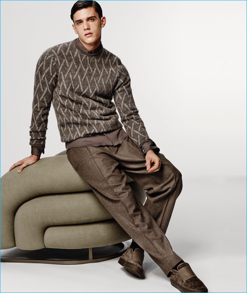 Xavier Serrano warms up to fall browns, wearing a smart sweater and trousers look from Giorgio Armani.