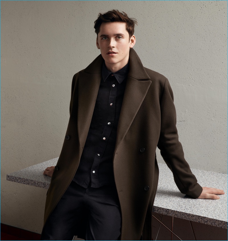 Anders Hayward embraces a chic moment in an oversized brown single-breasted coat from H&M's fall-winter 2016 Studio collection.