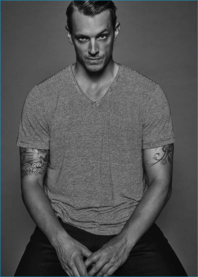 Joel Kinnaman goes casual in a striped AllSaints v-neck and Vince pants.