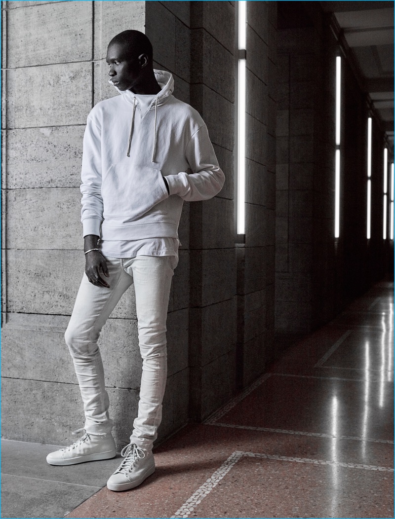 Pictured in a hoodie and skinny jeans, Fernando Cabral sports a light and casual ensemble from John Elliott's fall-winter 2016 collection.