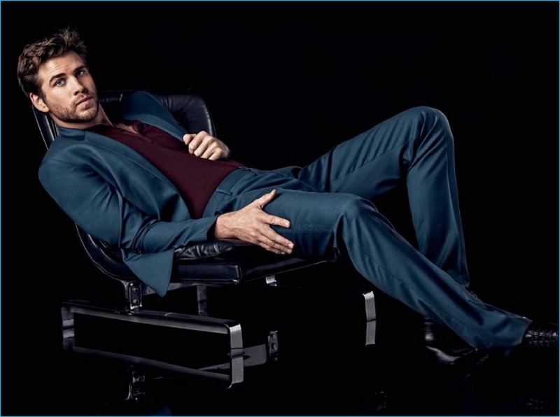 Liam Hemsworth wears a Dolce & Gabbana suit with a H&M polo shirt and Prada dress shoes.