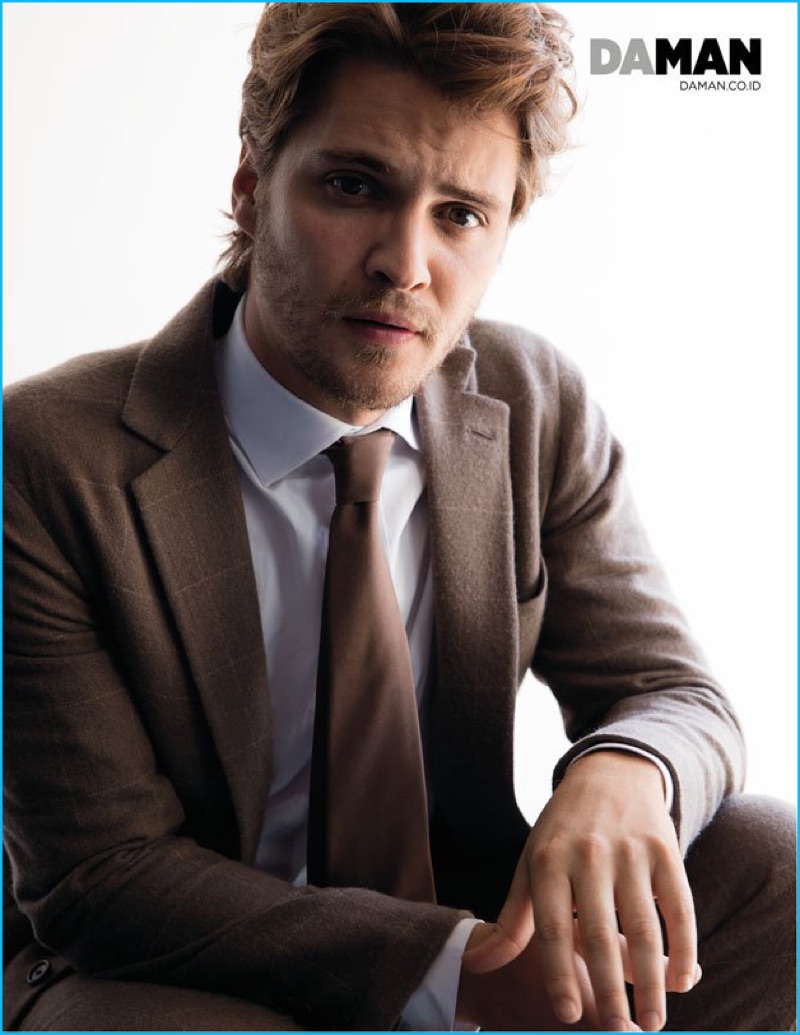 Luke Grimes pictured in a brown windowpane suit from Ralph Lauren.