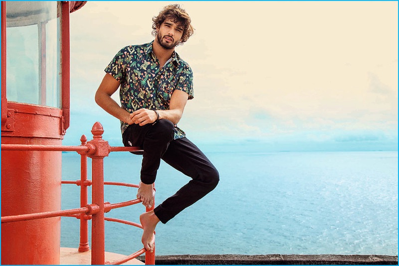 Marlon Teixeira goes casual in a tropical print short sleeve shirt and slim black pants for Mormaii's spring-summer 2017 campaign.