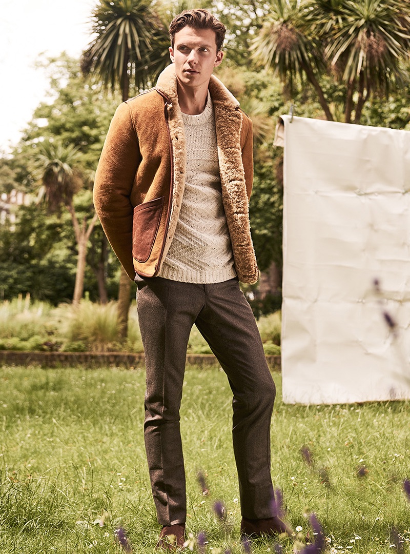 Samuel wears jacket YMC, sweater Samsoe & Samsoe, trousers Hacket London, and shoes Sebago.