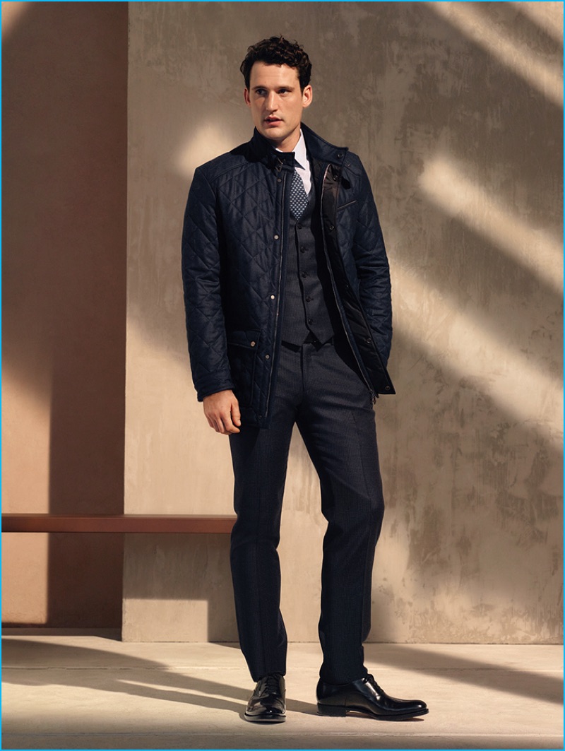 Sam Webb sports a navy quilted jacket over a waistcoat and trousers from Salvatore Ferragamo's pre-fall 2016 men's collection.