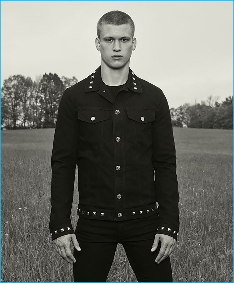 Zack Riddle dons a studded black denim jacket from Versace Jeans' fall-winter 2016 collection.