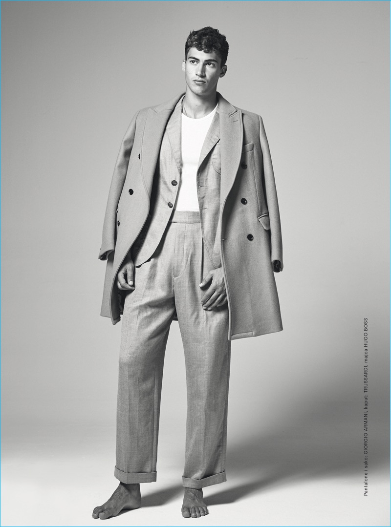 Alessio Pozzi sports a neutral Giorgio Armani suit with a Trussardi double-breasted coat and Hugo Boss t-shirt.