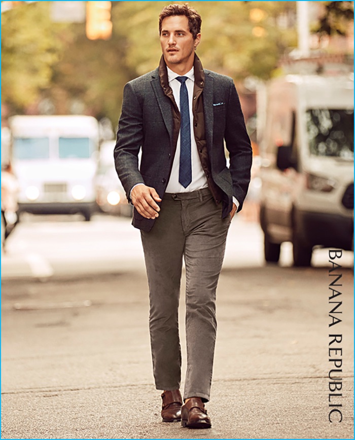 Ollie Edwards ventures outdoors, wearing Banana Republic's grey plaid blazer with corduroy pants, a white dress shirt, blue tie, quilted jacket, and brown leather dress shoes. 