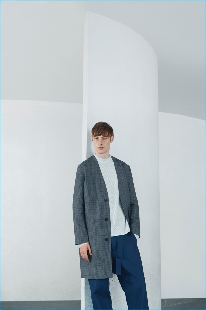 Roberto Sipos models a collarless coat from the COS x Agnes Martin collection.