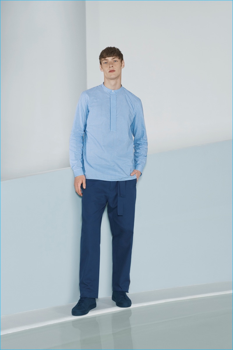 Roberto Sipos pictured in a blue collarless shirt from the COS x Agnes Martin collection.
