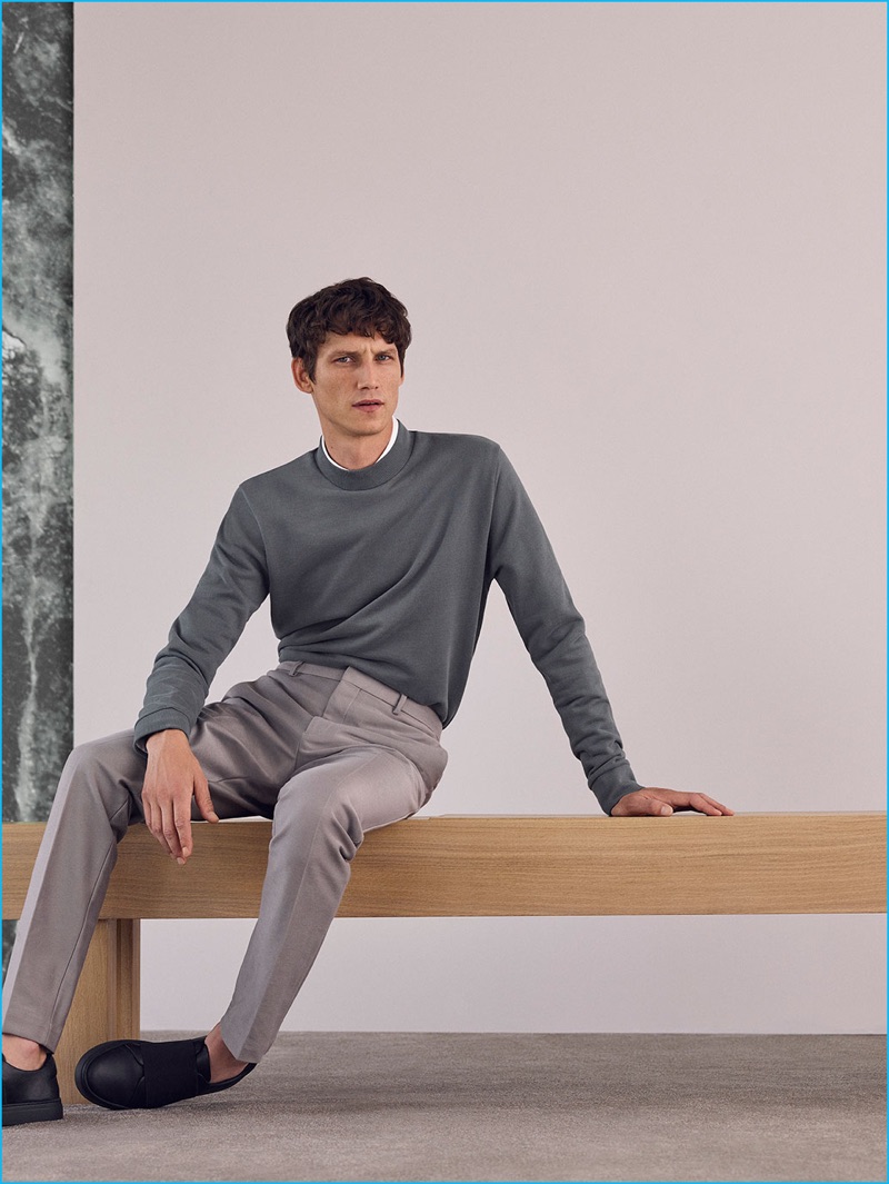 Roch Barbot dons a slim-fit cotton shirt, pleated trousers, and black wrap-over leather sneakers from COS' fall-winter 2016 Studio collection.