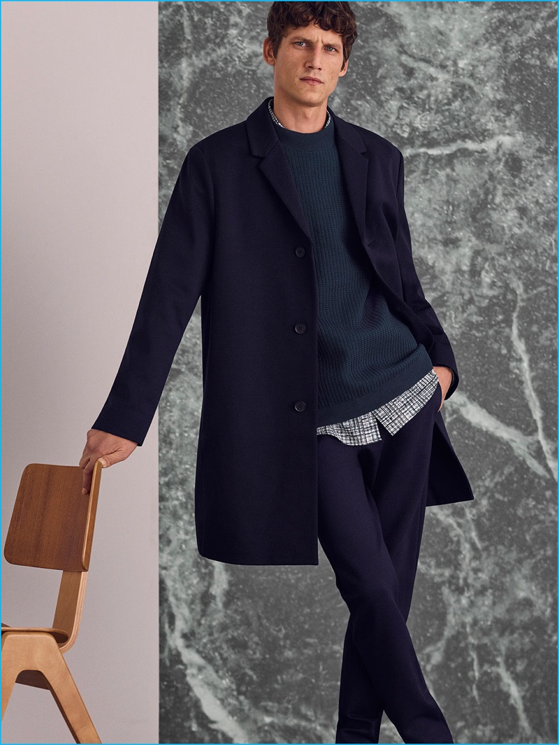 Roch Barbot sports a jersey coat, raised square knit sweater, printed cotton shirt, and zip-cuff jersey trousers from COS' fall-winter 2016 Studio collection.