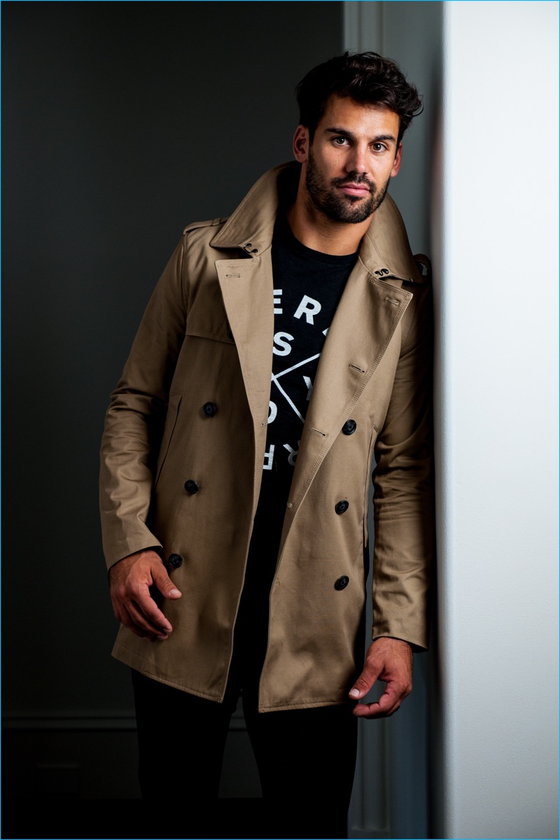 Eric Decker wears Superdry's Rogue trench coat, Surplus Goods graphic tee, and Corporal slim jeans for the brand's fall-winter 2016 campaign.