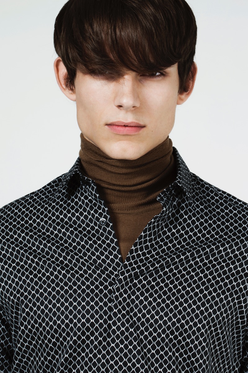Adrian dons a J.Lindeberg brown turtleneck, paired with a graphic print button-down shirt.
