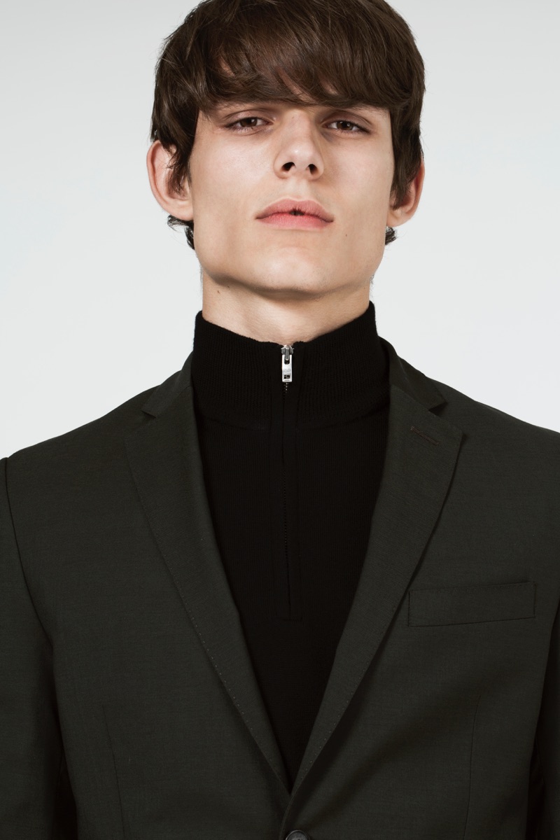 Adrian wears a trim blazer with a half-zip top from J.Lindeberg.