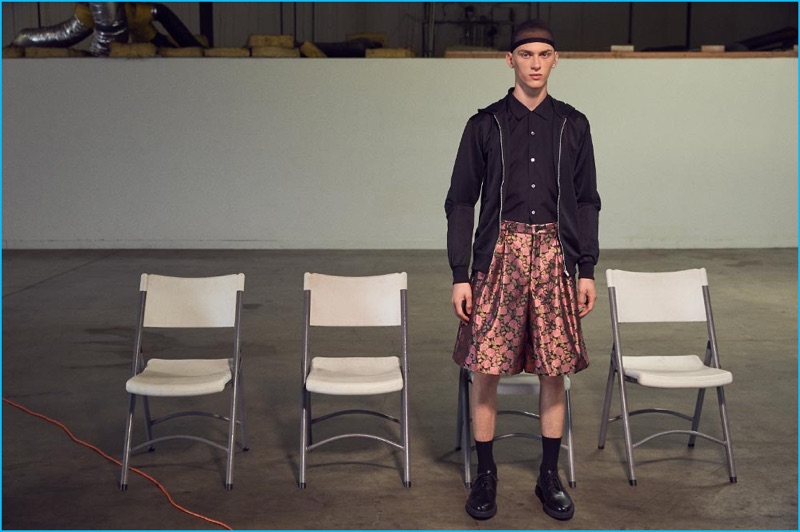 Dominik Sadoch wears waxed calfskin derbies Lanvin, jersey hoodie, broad shirt, and jacquard shorts Comme des Garçons Homme Plus.