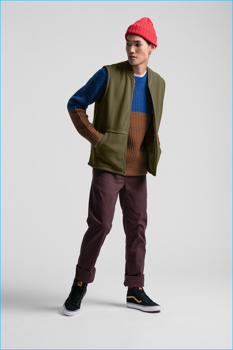 Danny Lim models a colorblocked knit sweater with a vest and burgundy pants from JackThreads.