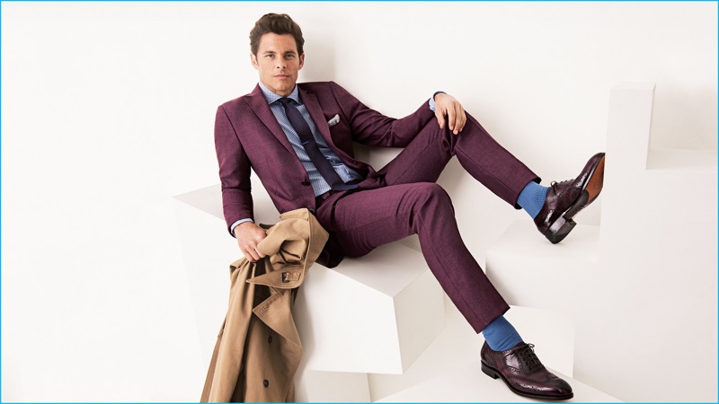 James Marsden dons an oxblood hued suit from Etro with patterned L.B.M. 1911 shirt, Burberry tie, The Kooples trench coat, Uniqlo socks, an Eleventy pocket square, and Salvatore Ferragamo shoes.