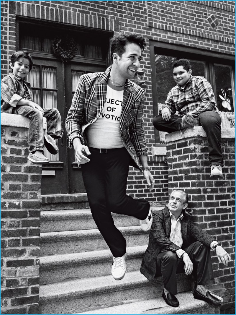 Captured in a black & white photo, Lin-Manuel Miranda wears a Prada sports jacket and pants from Prada with an Icons t-shirt, and Golden Goose Deluxe Brand sneakers for GQ.